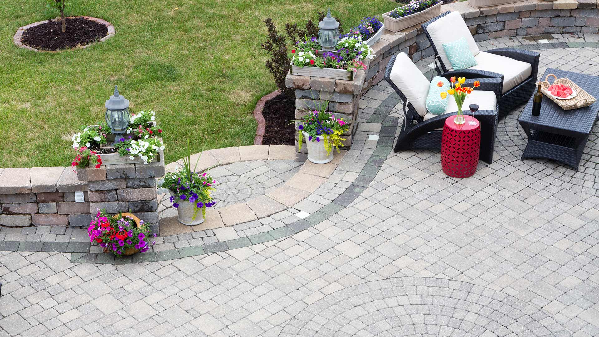 A paved stone patio with black and red furniture by a home in Downingtown, PA.
