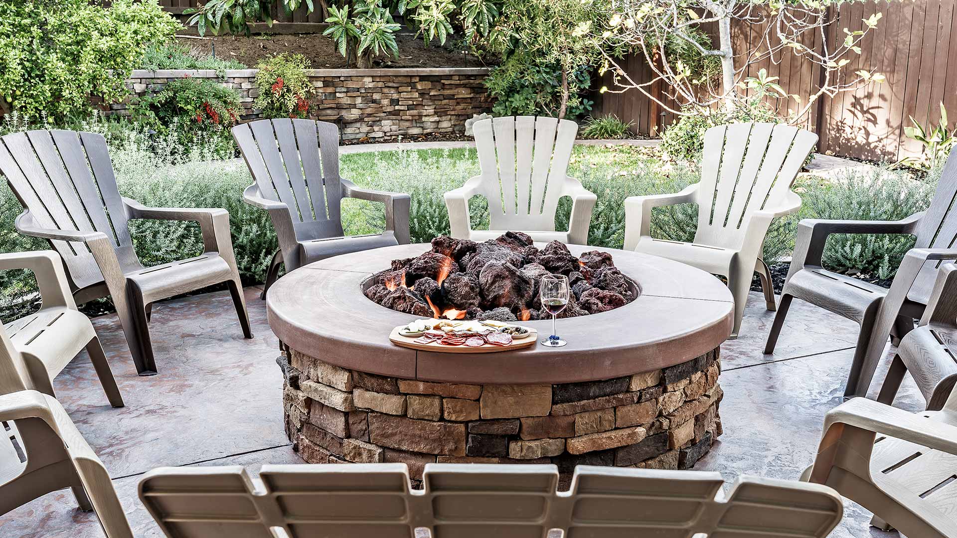 An outdoor stone fire pit surrounded by a stone patio and walkway in West Chester, PA.