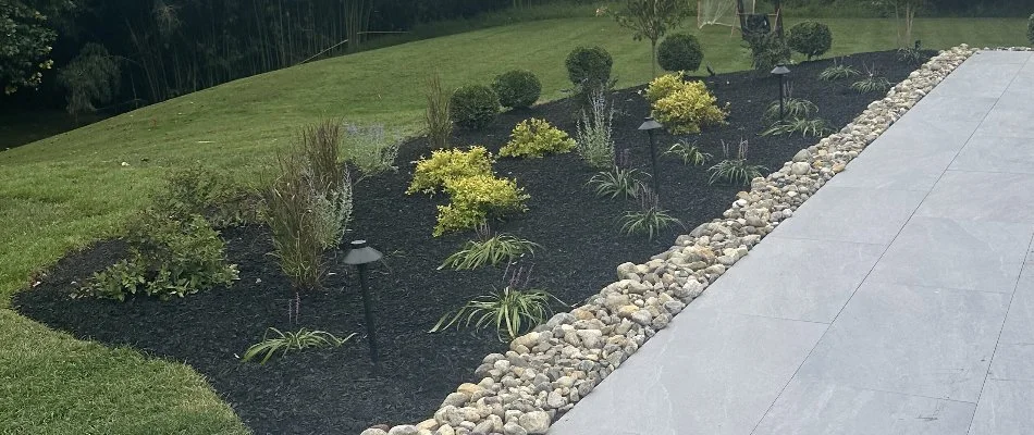 Landscape bed in West Chester, PA, with mulch and plants.