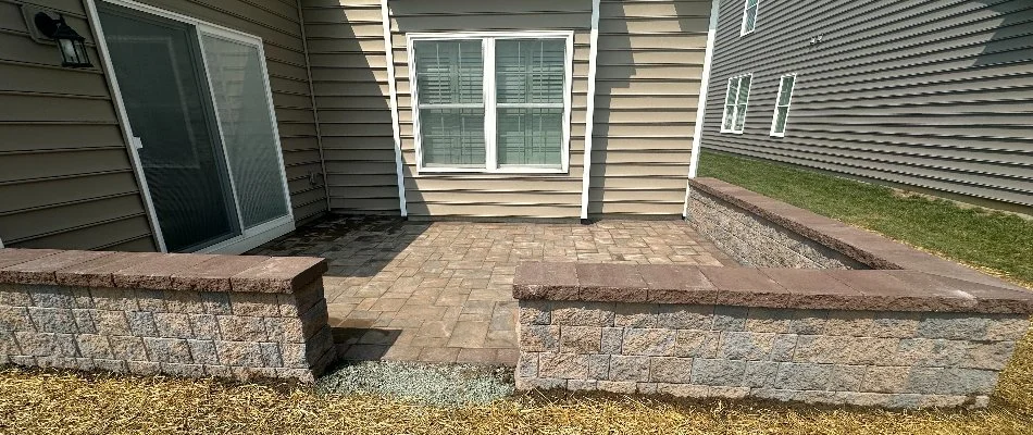 Natural stone paver patio in West Chester, PA, with seating wall.