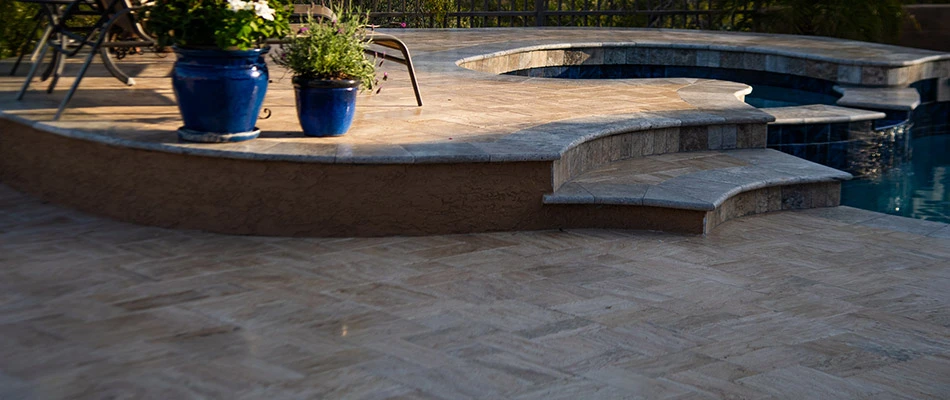 A travertine patio built along a pool in Downingtown, PA.
