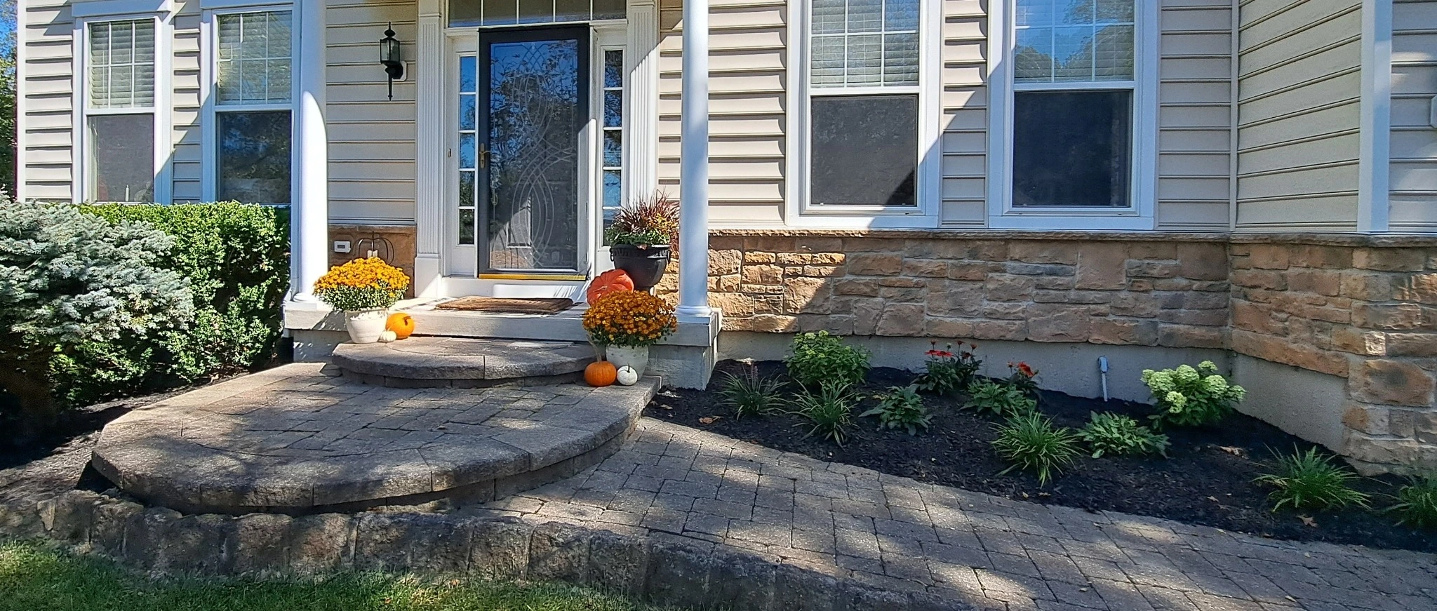 A landscape bed of various bushes and flowers by a home in West Chester, PA.