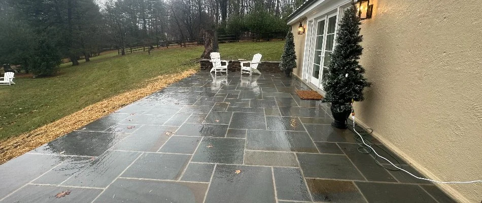 Bluestone patio with two white chairs on a property in Chester Springs, PA.