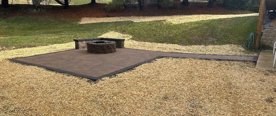 Patio in Malvern, PA, with a walkway, seating wall, and fire pit.