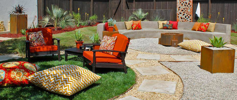 A rock and stone patio compete with fire pit and black and orange furniture in West Chester, PA.