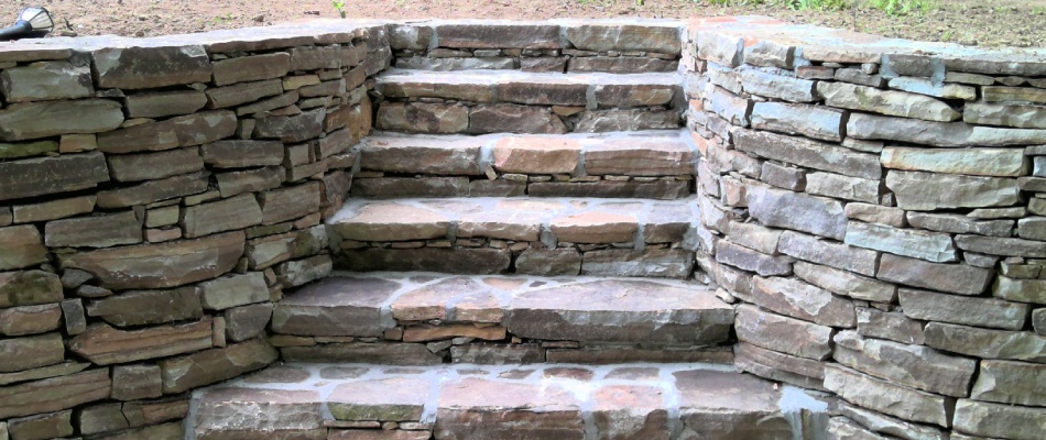 Stone outdoor steps installed with retaining wall in West Chester, PA.